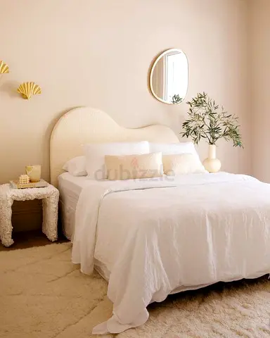 Queen bed with upholstered headboard and side table — neutral, gently used