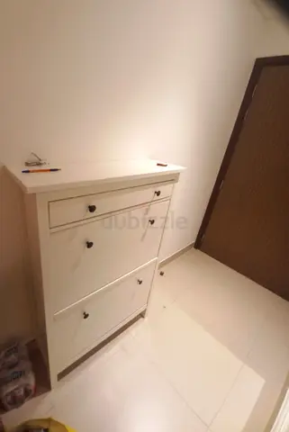 White hallway shoe cabinet with two tilt-out compartments