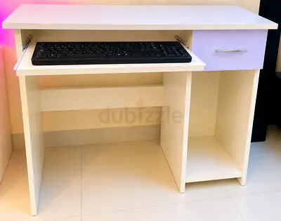 Compact white computer desk with keyboard tray and storage shelf