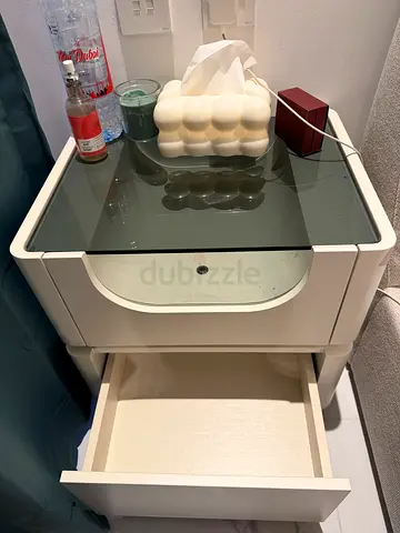 Modern white bedside table with glass top and drawer