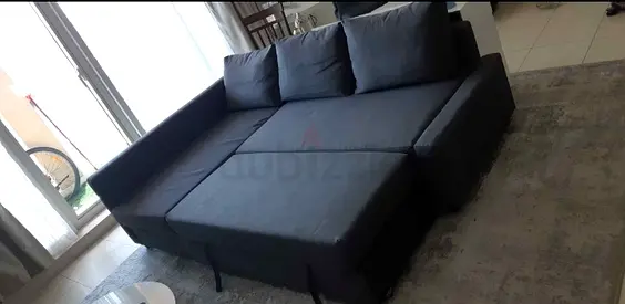 Dark grey L-shaped sofa bed with removable cushions - good condition