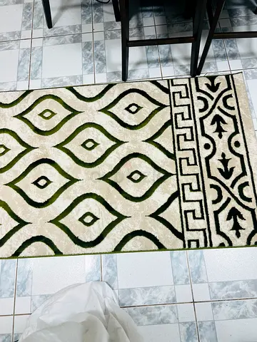 Used patterned area rug in green, black and cream - good condition