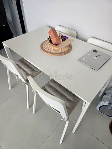 Selling an IKEA dining table with 4 matching chairs in white.