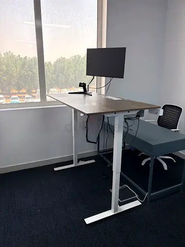 Height-adjustable office desk with monitor arm (monitor not included)