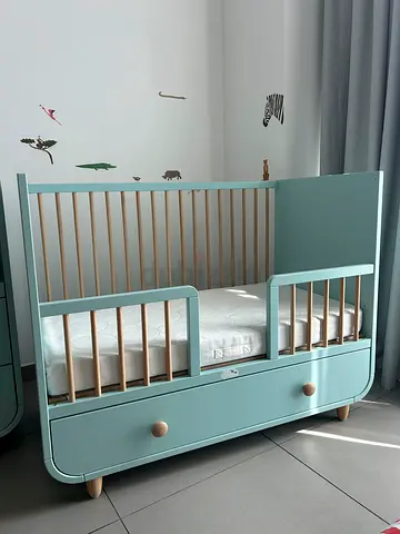 Mint green convertible baby crib with storage drawer