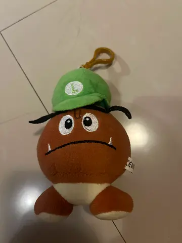 Small brown plush Goomba toy with green cap