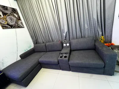 L-shaped dark grey fabric sectional sofa with storage arm console