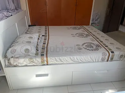 White queen size bed with mattress.