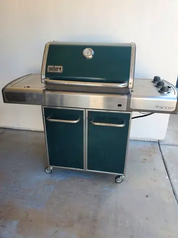 Weber Genesis E-310 gas grill, identifiable by its unique dark green porcelain-enameled hood