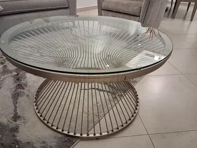 Round glass-top coffee table with metal spindle base