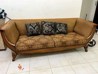 Classic carved wooden 3-seater sofa with patterned cushions
