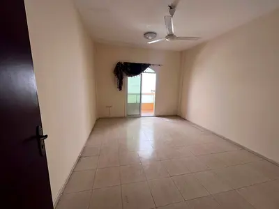 Studio apartment for rent in Ajman, annual rental, with balcony, separate kitchen, and central air conditioning, located in Al Muwaihat 2 area.