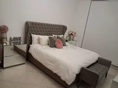 king bed with two side table, bench and vanity
