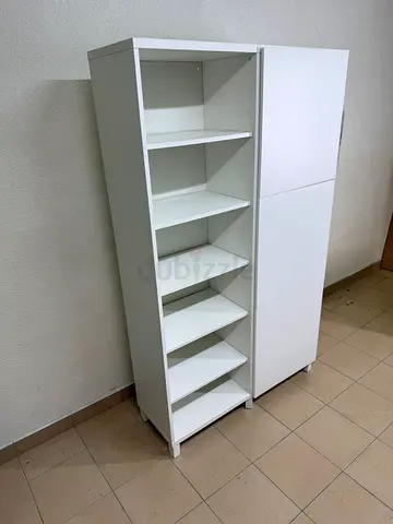 A white storage cabinet from IKEA, model BESTÅ, comes with open units and closed fronts.