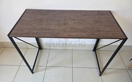 Compact industrial-style study desk with wood top and metal frame.
