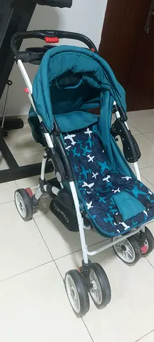 Lightweight teal baby stroller with reclining seat and storage basket