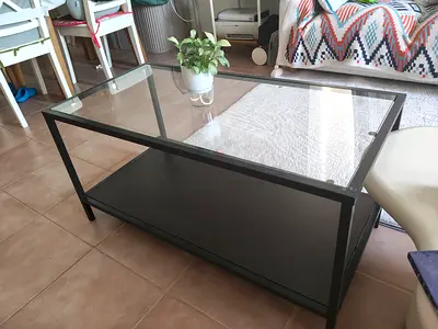 Glass top black metal coffee table with lower shelf