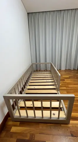 Custom made montessori floor bed with round rails. Made from solid wood.