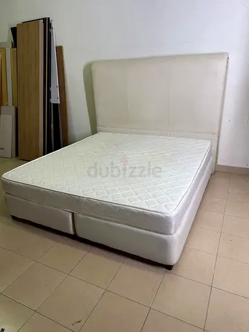 Beige upholstered double bed with mattress