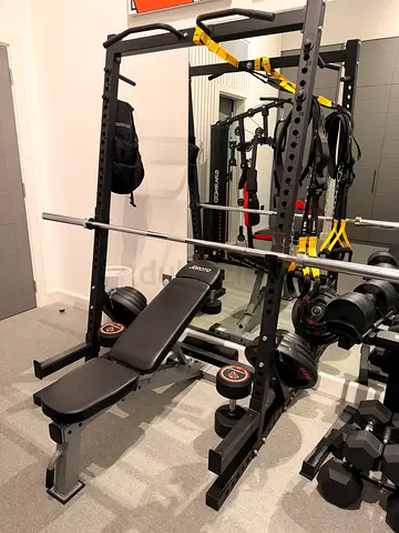 Bench press rack, barbell, bench, weights.