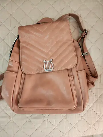 Light brown leather backpack with front pocket and quilted flap — good used condition