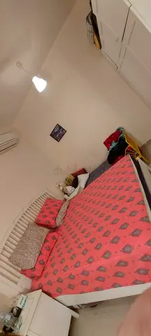 White wooden single bed frame with mattress and bedding