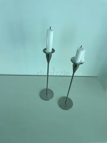 Pair of Piet Hein stainless steel tall candle holders with candles