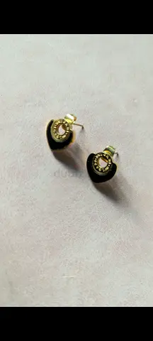 Small gold-tone stud earrings with black crescent detail - pair