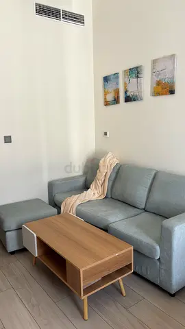 Light grey 3-seater sofa with ottoman and wooden coffee table