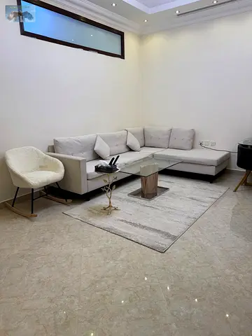 Two-bedroom furnished apartment with a living room for rent in Ajman, Al Rawda 3. Features include two bathrooms, a balcony