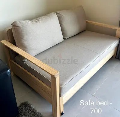 Solid wood sofa bed with neutral cushions - light pine frame