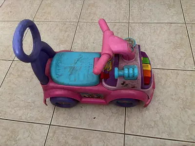 Used pink ride-on baby car with musical buttons - needs cleaning