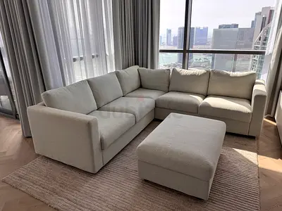 Light grey L-shaped fabric sofa with ottoman - good condition