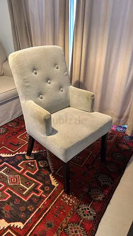 Light grey upholstered accent chair with button tufting