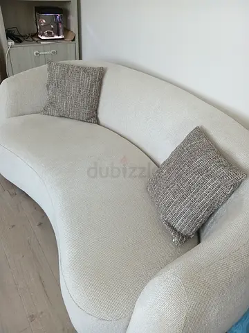 Curved Cream Two-Seater Sofa with Two Cushions