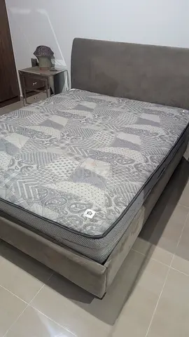 Grey upholstered double bed frame with mattress - good condition. From THE ONE. 1500dhs