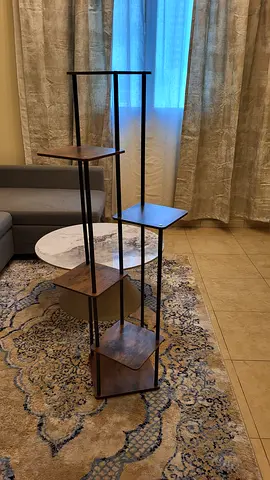 Tall black metal plant stand with plywood flat platform