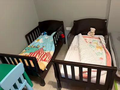 Pair of dark wood toddler beds (2) with mattresses