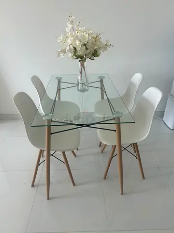 Glass top dining table and four white chairs