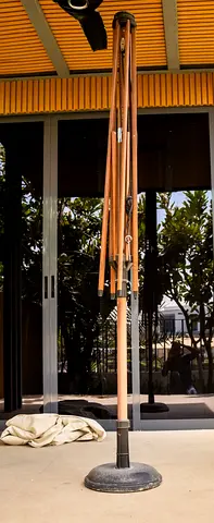 Used outdoor patio umbrella with weighted base — folding, wooden pole