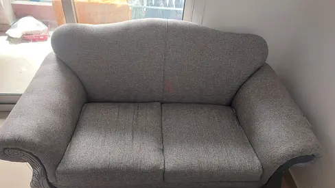 Two-seater grey fabric sofa in good used condition