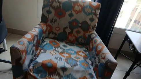 Comfortable single upholstered armchair with patterned fabric