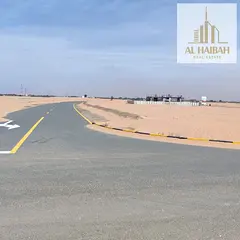 Residential lands for sale in Sharjah, Al-Zubair Gardens area, opposite the Emirates Transnational R