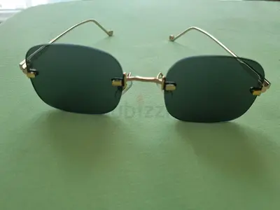 Gold-frame rimless sunglasses with black lenses