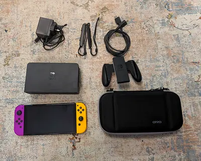Nintendo Switch oled console with dock, Joy-Con controllers, grip, charger and carrying case