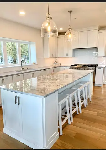 Large White Kitchen Island with Marble Top and Seating