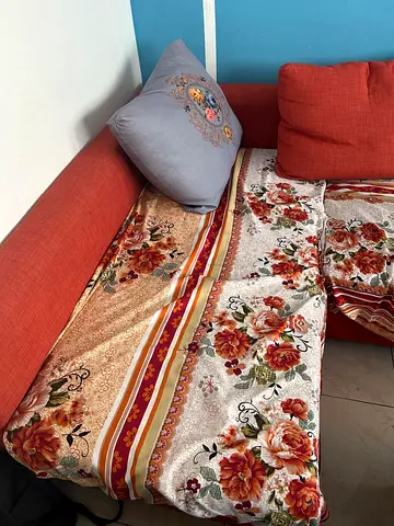 Orange L-shaped Sofa with Floral Throw (Good Used Condition)
