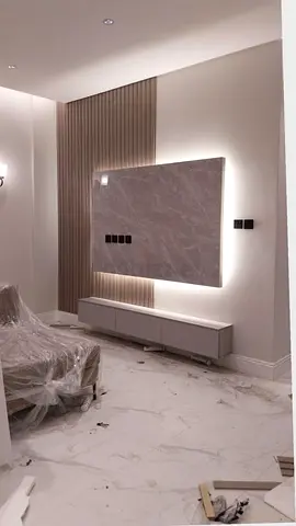 Modern wall-mounted TV panel with backlit marble finish and low console