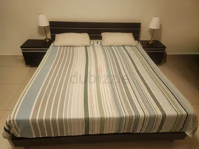 King size bed with two side tables lamps and mattress