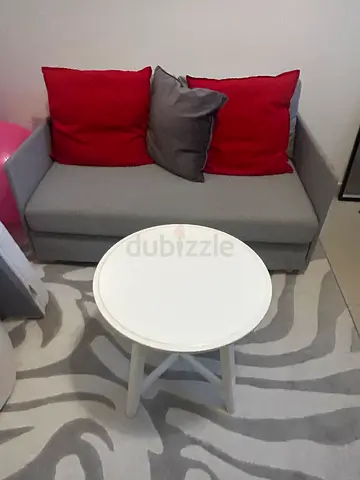 Grey small sofa bed, with a mattress and small coffee table